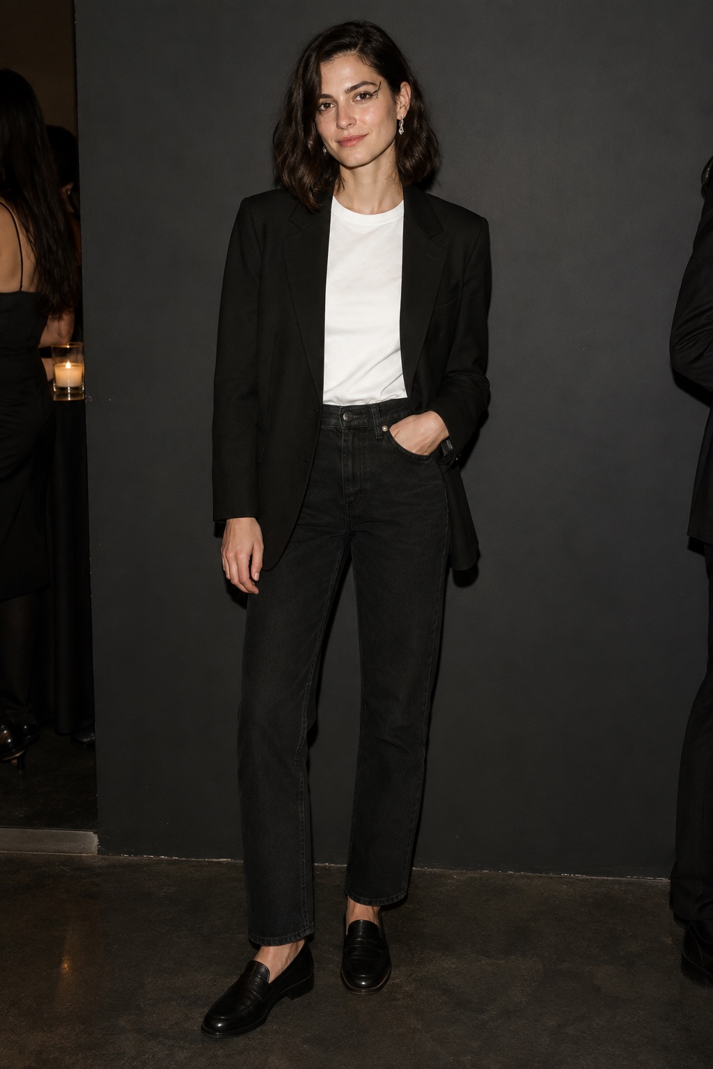 Minimal skeleton-inspired outfit with black blazer, black jeans, white tee and subtle eye makeup.