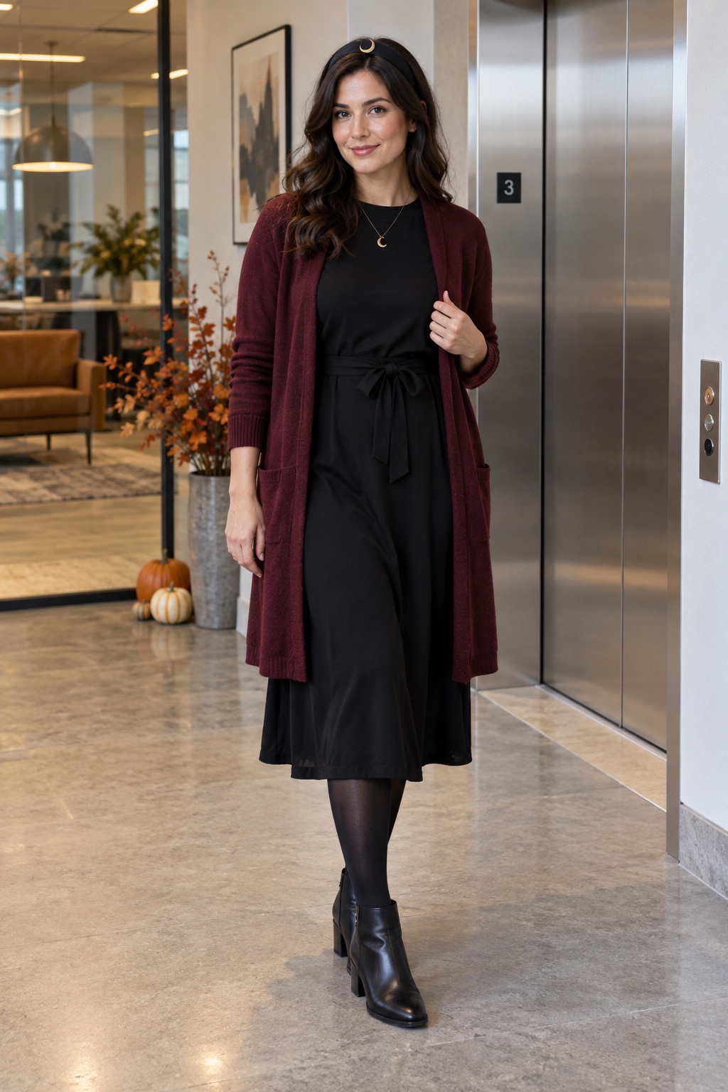 Office witch costume with a black midi dress, burgundy cardigan, tights and ankle boots.